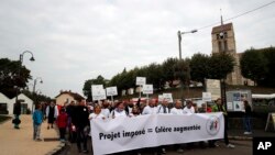 Warga Forges-les-Bains, selatan Paris, Perancis, melakukan aksi unjuk rasa, Sabtu (8/10) memprotes kedatangan migran yang sedang disebar ke seluruh negara itu sejak pemerintah menutup kamp di Calais. (AP Photo/Christophe Ena)