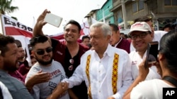 Presidential hopeful and two-time candidate Andres Manuel Lopez Obrador greets supporters as he arrives at a campaign rally for Delfina Gomez, who is running for Mexico state governor with his National Regeneration Movement, or MORENA, in Nezahualcoyotl, Mexico state, May 28, 2017. 