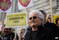 FILE - David Freiberg, who played with the Quicksilver Messenger Service and Jefferson Airplane bands, speaks in support of a Summer of Love anniversary concert during a rally outside City Hall in San Francisco, Feb. 16, 2017.
