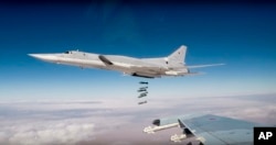 FILE - In this photo made from footage taken from the Russian Defense Ministry website on Nov. 26, 2017, Russian Tu-22M3 long-range bombers strike Islamic State targets in Syria.