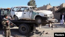 지난 4일 탈레반의 공격으로 파괴된 차량 주변을 수색하는 아프가니스탄 경찰들. (자료사진)