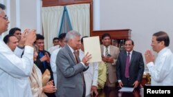 Ranil Wickremesinghe, ousted as prime minister in October, takes his oath for the same post before Sri Lanka's President Maithripala Sirisena during his swearing-in ceremony in Colombo, Sri Lanka, Dec. 16, 2018.