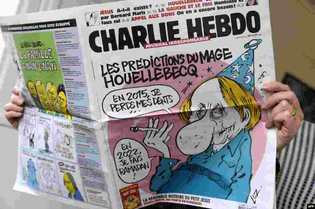 Uma pessoa lê a última edição do jornal Charlie Hebdo após homens armados com Kalashnikovs e um lança-rocket terem aberto fogo nos escritórios do semanário satírico matando 12 pessoas. Paris, Jan. 7, 2015.