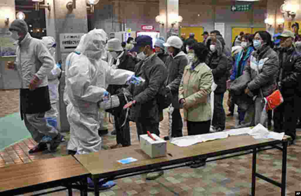 Evacuees are screened for radiation exposure at a testing center in Koriyama city, Fukushima prefecture, Japan, after a nuclear power plant on the coast was damaged by Friday's earthquake and tsunami, March 15, 2011