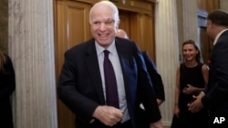 Sen. John McCain, R-Ariz., smiles as he arrives to vote as the Republican-run Senate rejected a GOP proposal to scuttle President Barack Obama's health care law, July 26, 2017, in Washington.