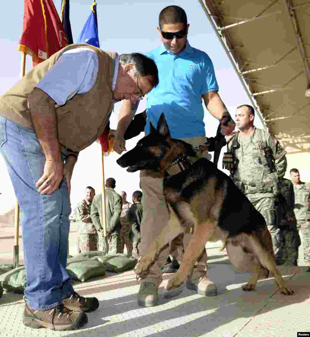 U.S. Defense Secretary Leon Panetta (L) greets Fando and his handler Jose Lebron of San Juan, during a visit with troops at Ali Al Salem Air Base in Kuwait, December 12. 