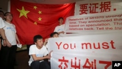 Newly arrived Chinese relatives of passengers on board the missing Malaysia Airlines flight MH370 shouts slogans as they speak to reporters at a hotel in Subang Jaya, Malaysia, Sunday March 30, 2014.