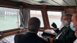 In this photo released by the Suez Canal Authority, Lt. Gen. Ossama Rabei, head of the Suez Canal Authority, second right, speaks to other staff onboard a boat near the stuck cargo ship Ever Given on Wednesday, March 24, 2021.
