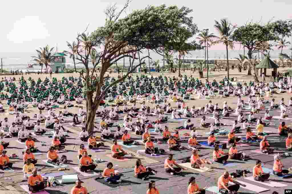 Para penggemar berat yoga ikut serta dalam sebuah sesi yoga massal di lapangan ampitheater di Pantai Utara, Durban, Afrika Selatan.