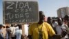 A protester carries a sign reading "Zida is Judas Iscariot," referring to coup leader Lt. Col. Yacouba Isaac Zida, in Ouagadougou, capital of Burkina Faso, Nov. 2, 2014. 