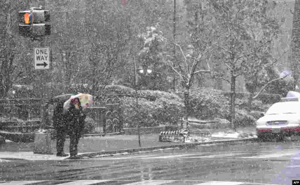 Les piétons subissent la dernière tempête qui frappe la côte est des États-Unis, le 21 mars 2018, à Washington, DC.