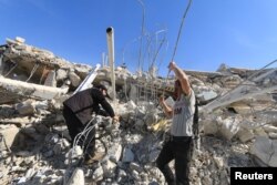 People look for survivors in the ruins of a destroyed Medecins Sans Frontieres (MSF) supported hospital hit by missiles in Marat Numan, Idlib province, Syria, February 16, 2016.