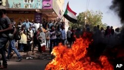 FILE: People chant slogans and burn tires during a protest to denounce the October 2021 military coup, in Khartoum, Sudan, Jan. 6, 2022.