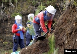 FILE - Natalia Arango works with her mine detector in a zone of land mines planted by rebel groups near Sonson in Antioquia province, Colombia, Nov. 19, 2015.