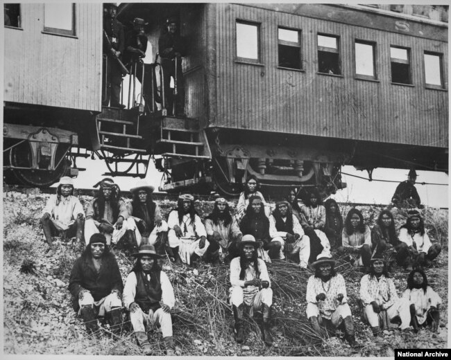 Geronimo (front row, third from right) and his Chiricahua followers as prisoners of war en route to Florida, 1886.