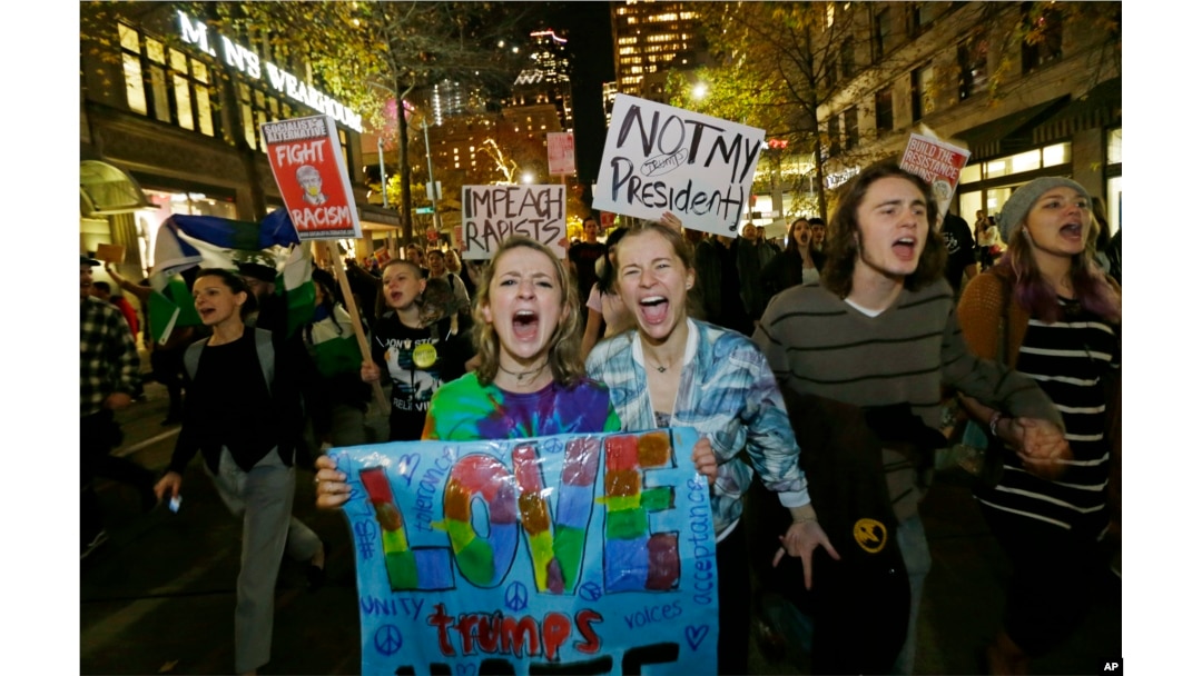 Protesters chant and hold signs during a protest against the election of President-elect Donald Trump, Nov. 9, 2016, in downtown Seattle.