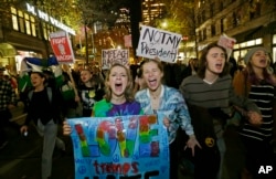 Protesters chant and hold signs during a protest against the election of President-elect Donald Trump, Nov. 9, 2016, in downtown Seattle.