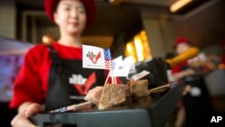 A hostess holds a tray of sliced American beef at an event to celebrate the re-introduction of American beef imports to China in Beijing, June 30, 2017. 