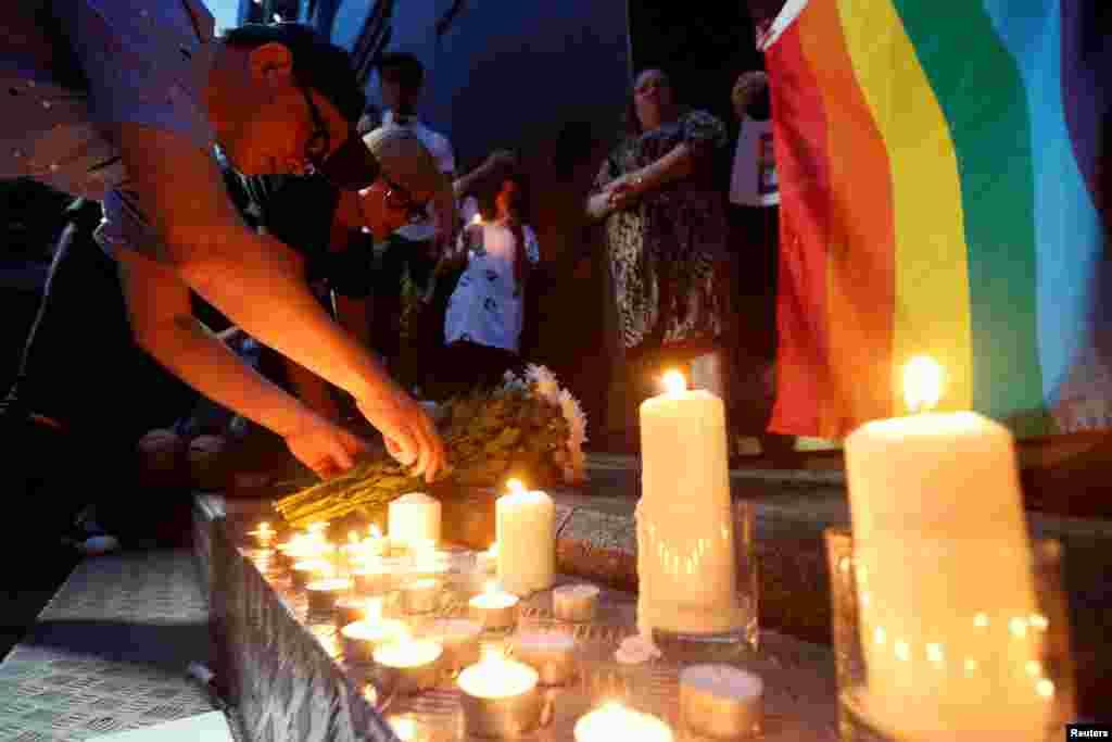 Os cantores Anthony Wong, esq, e Denise Ho, que anunciaram serem homossexuais, deixam flores durante uma vigílai de velas pelas vítimas do ataque em Orlando, na discoteca Pulse. Vigília em Hong Kong, China, Junho 13, 2016.