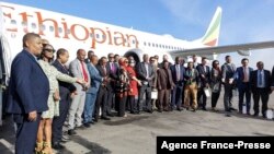 Ethiopian Airlines employees pose for a group photo in front of a Boing 737 MAX on the tarmac of the Bole International Airport in Addis Ababa, Feb. 1, 2022. 