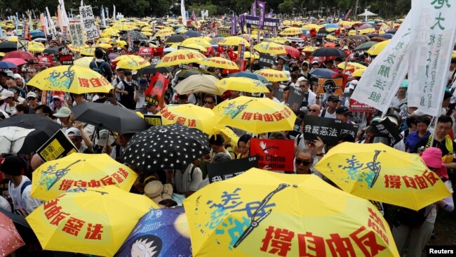 2019年6月9日在中国香港，示威群众要求当局废除拟议中的把犯人引渡到中国的法案。他们手持黄色遮阳伞，这是过去的占领中环运动的象征。