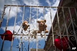 Plush toys, recovered from a flooded home, hang out to dry on a wrought iron gate in the community of Ingenio in Toa Baja, Puerto Rico, Oct. 2, 2017.