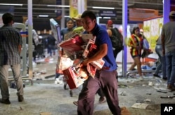 A man runs with toys as a store is ransacked by a crowd in the port of Veracruz, Mexico, Jan. 4, 2017.