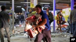 FILE - A man runs with toys as a store is ransacked by a crowd in the port of Veracruz, Mexico, Wednesday Jan. 4, 2017.
