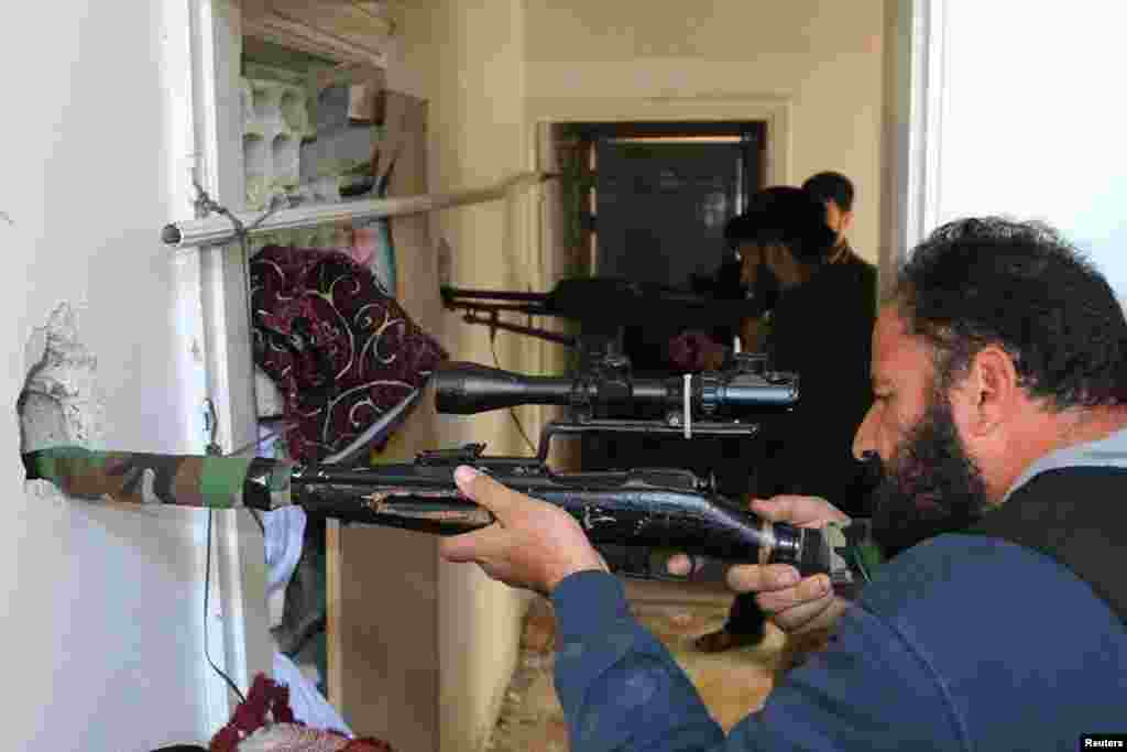 Rebel fighters aim their weapons inside a building near the frontline against forces loyal to Syria&#39;s President Bashar al-Assad in al-Manshiyeh neighborhood in Deraa, Dec. 7, 2014.