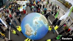 Los manifestantes protestan durante una manifestación celebrada el día antes del inicio de la Cumbre sobre el Cambio Climático de París en Berlín, Alemania, el 29 de noviembre de 2015. 