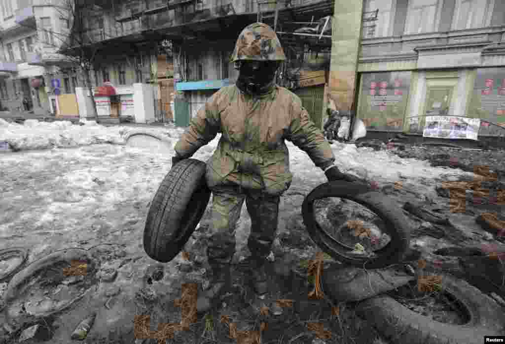 Um manifestante anti-governo retira as barricadas do local onde aconteceram os recentes confrontos com a polícia de choque em Kiev,&nbsp; Fev. 16, 2014.&nbsp;