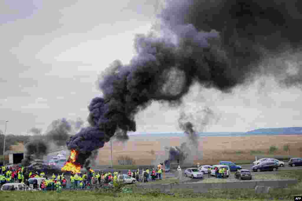 Demonstrators protesting the government&#39;s pensions overhaul burn tires as they block the entry of the industrial area of Le Havre&#39;s harbor, northwestern France.