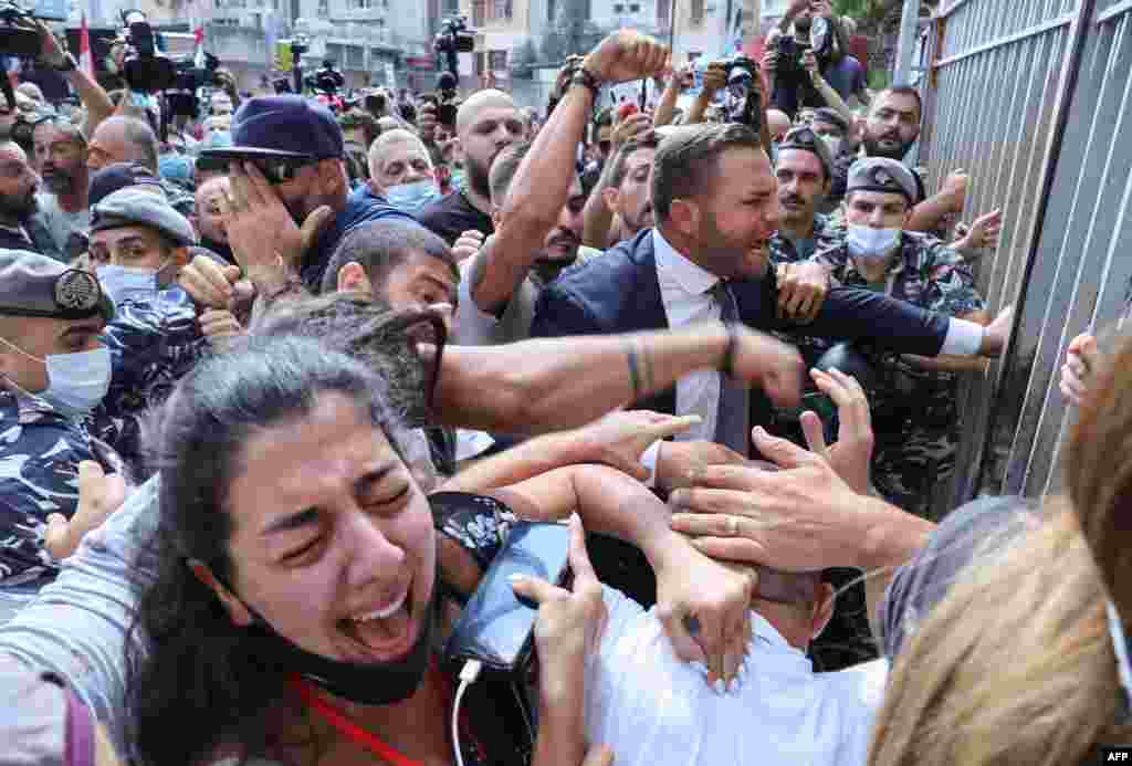 Activists and family members of victims of the Beirut port explosion are seen as Lebanese security members try to interfere during a demonstration outside the capital&#39;s Justice Palace, to protest the suspension of the investigation into the August 4, 2020, port explosion.