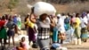 FILE: A woman carries food distributed by the United Nations World Food Programme (WFP) in Mwenezi, about 450 kilometers (280 miles) south of Harare, Zimbabwe, Wednesday, Sept. 9 2015.