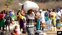 FILE: A woman decants palmoil distributed by the United Nations World Food Programme (WFP) in Mwenezi, about 450 kilometers (280 miles) south of Harare, Zimbabwe, Wednesday, Sept. 9 2015.