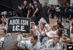 Cientos de activistas protestan contra el enfoque de la administración Trump sobre los cruces fronterizos ilegales y la separación de niños de padres inmigrantes, en el edificio de oficinas Hart del Senado en el Capitolio, Washington, el jueves 28 de junio de 2018.