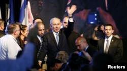 Israeli Prime Minister Benjamin Netanyahu, center, waves to supporters at party headquarters in Tel Aviv, March 18, 2015. 