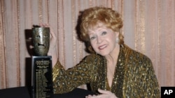 FILE - Debbie Reynolds, shown with her SAG Lifetime Achievement Award in January 2015, rose to fame in 1952's "Singin' in the Rain" and earned an Oscar nomination for 1964's "The Unsinkable Molly Brown."