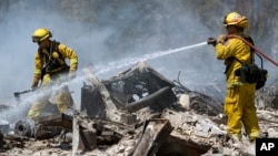 Carlos Orta (phải) dập đám cháy còn âm ỉ ở một ngôi nhà tại Lower Lake, California, ngày 15 tháng 8 năm 2016.
