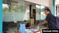 Seorang pengunjung membersihkan tangan yang disediakan kantor BBTKLPP Yogyakarta. (Foto:VOA/ Nurhadi)