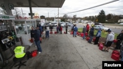 People affected by the power outages from Hurricane Sandy wait in line at a gas station to purchase fuel for generators in Madison Park, New Jersey, October 31, 2012. 