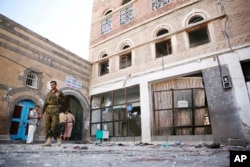FILE - Shiite fighters, known as Houthis, inspect the the scene at the al-Balili mosque after two suicide bombings at the mosque during Eid al-Adha prayers in Sanaa, Yemen, Sept. 24, 2015.