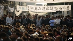 Residents of Wukan, a fishing village in the southern province of Guangdong, rally to demand the government take action over illegal land grabs and the death in custody of a local leader on December 15, 2011.
