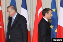 FILE - French President Emmanuel Macron (R) and his Turkish counterpart, Recep Tayyip Erdogan, walk past each other during a joint press conference at the Elysee Palace in Paris, France, Jan. 05, 2018.