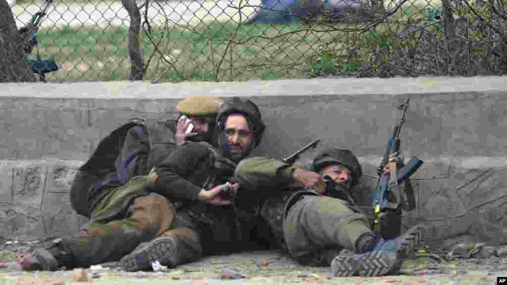 Indian police take cover during a gun battle in Srinagar, India, March 13, 2013.