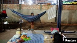 Venezuelan women are pictured near their improvised beds during the night at the car repair shop, near the interstate Bus Station in Boa Vista, Roraima state, Brazil, Aug. 24, 2018. 