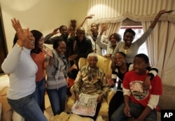 FILE - Former South Africa's President Nelson Mandela poses with his grandchildren, at his home in Qunu, South Africa.