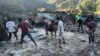 Des personnes pataugent dans une zone inondée à Dipayal Silgadhi, au Népal, le jeudi 21 octobre 2021.