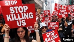 Protesters hold placards as they attend a demonstration demanding Hong Kong's leaders to step down and withdraw the extradition bill, in Hong Kong,, June 16, 2019. 