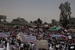 A group of protesters from the Sudanese medical profession syndicate march at the sit-in inside the Armed Forces Square, in Khartoum, Sudan, Wednesday, April 17, 2019.